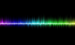 Black background with the rainbow colored peaks and valleys of sound waves across the center.