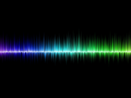 Black background with the rainbow colored peaks and valleys of sound waves across the center.